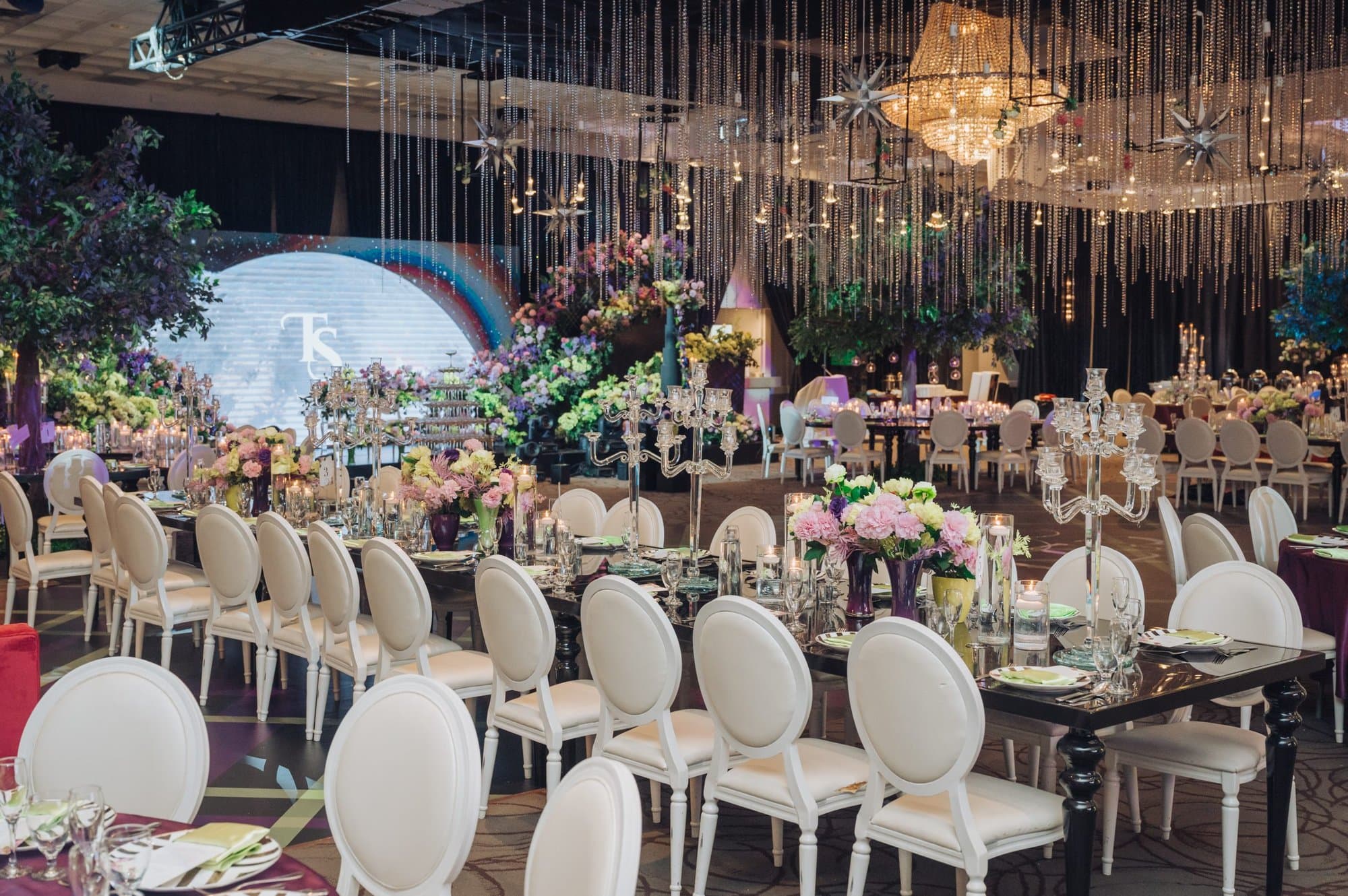 Wedding reception hall with a floral head table and elegant lighting